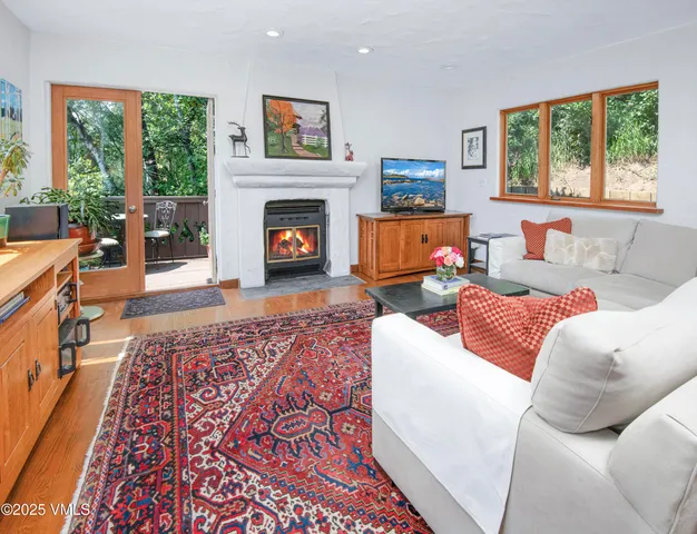 a living room with furniture large window and a fireplace