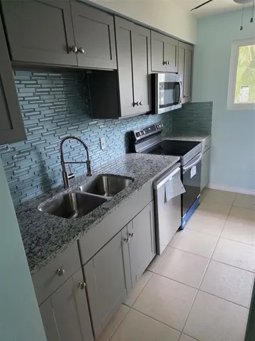 a kitchen with stainless steel appliances granite countertop a sink a stove a microwave and cabinets