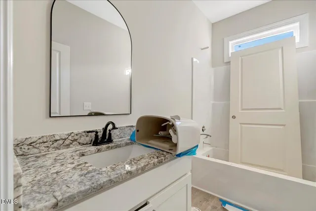 a bathroom with a granite countertop sink and a mirror