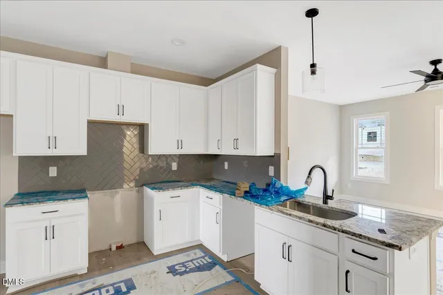 a kitchen with granite countertop white cabinets and white appliances