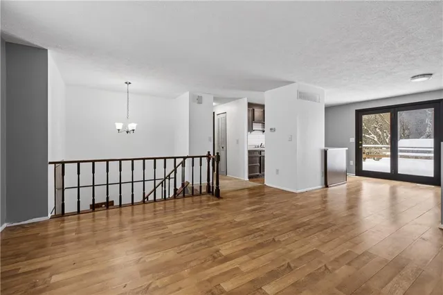a view of a hallway with wooden floor and windows
