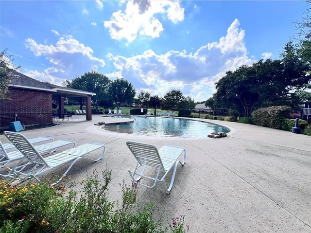 a view of a patio with a table and chairs under an umbrella