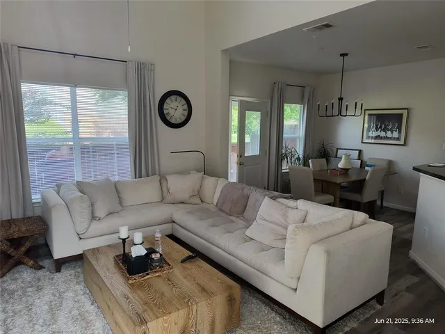 a living room with furniture a window and a clock