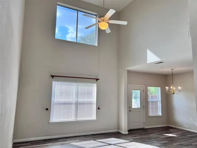 an empty room with windows and fan