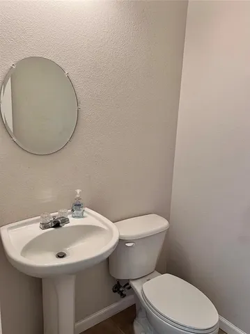 a white toilet sitting next to a bathroom sink