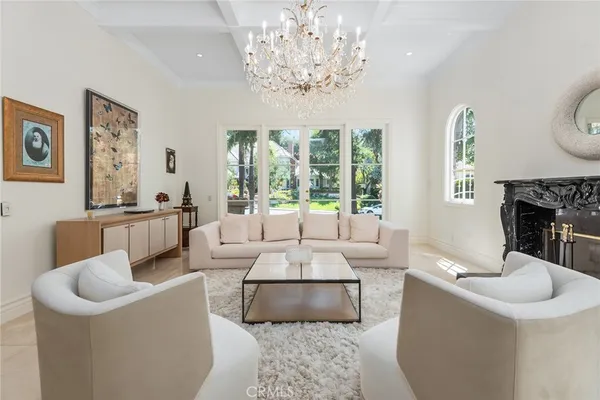 a living room with furniture a large window and a chandelier