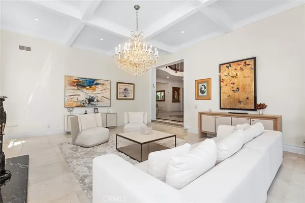a living room with furniture and a chandelier