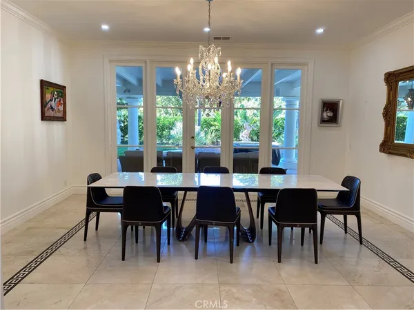 a dining room with furniture a chandelier and window
