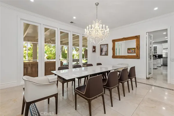 a view of a dining room with furniture a chandelier and window