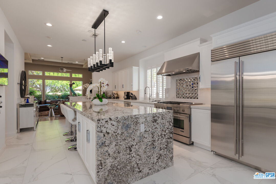 53 Vista Encantada Rancho Mirage, CA 92270 - Photo 11 of 33 a kitchen with kitchen island granite countertop a refrigerator a stove top oven a dining table and chairs