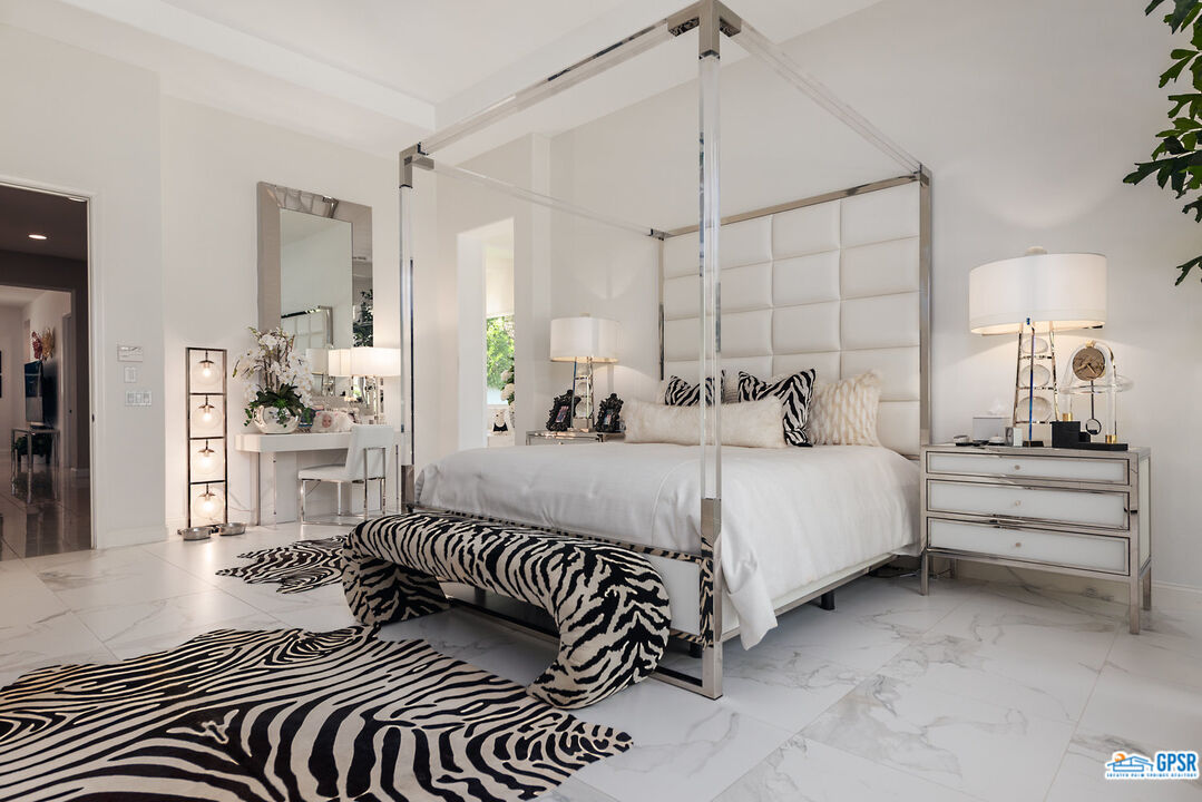 53 Vista Encantada Rancho Mirage, CA 92270 - Photo 14 of 33 a bedroom with a bed and a chandelier