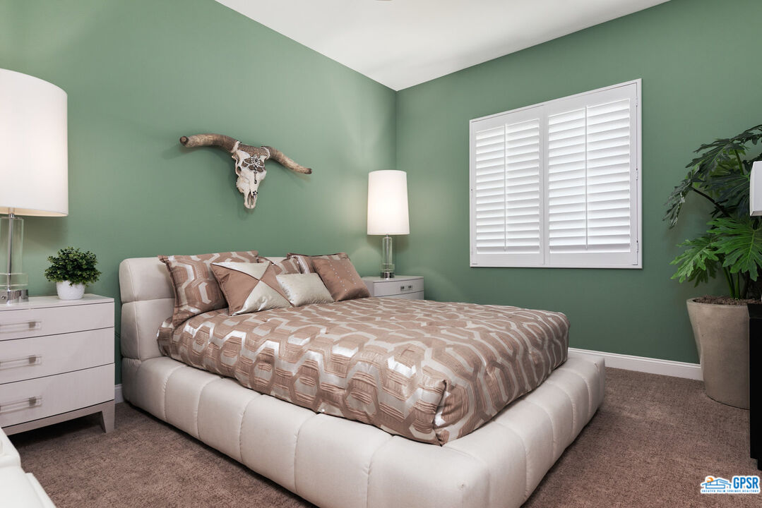 53 Vista Encantada Rancho Mirage, CA 92270 - Photo 21 of 33 a bedroom with a large bed and a potted plant