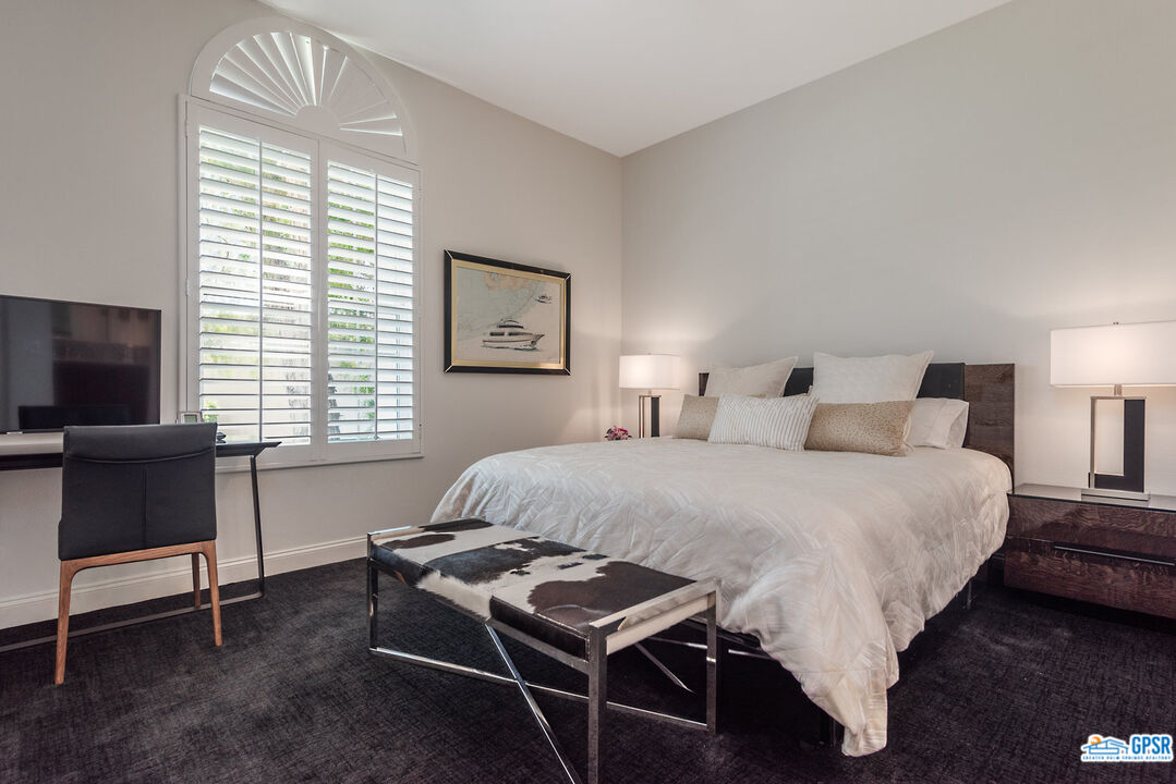 53 Vista Encantada Rancho Mirage, CA 92270 - Photo 22 of 33 a bedroom with a bed and a chair