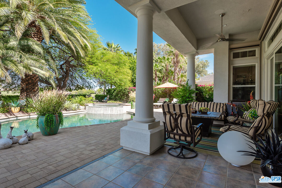 53 Vista Encantada Rancho Mirage, CA 92270 - Photo 25 of 33 a view of a patio with couches chairs potted plants and a large tree