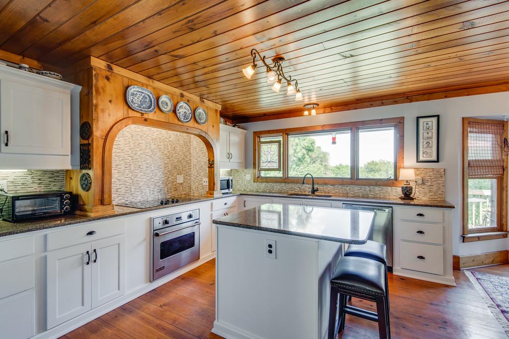 790 High Point Ridge Road Franklin, TN 37069 - Photo 9 of 30 a kitchen with stainless steel appliances granite countertop a stove a sink dishwasher and white cabinets with wooden floor