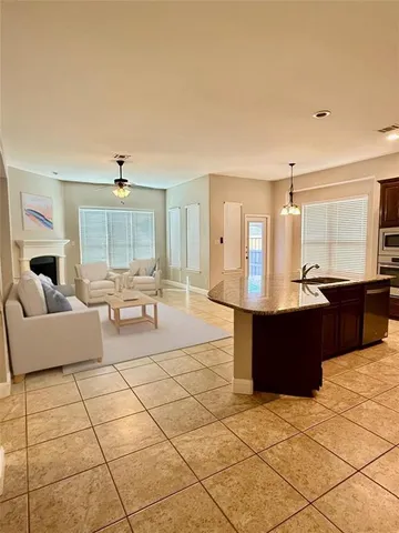 a living room with couches and kitchen view with wooden floor