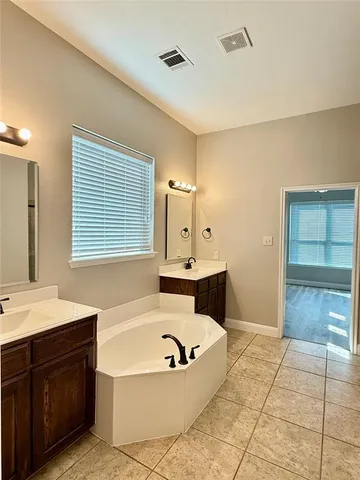 a bathroom with a tub sink and mirror