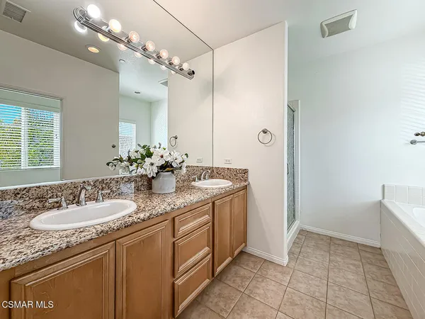 a bathroom with a granite countertop sink a toilet and a shower