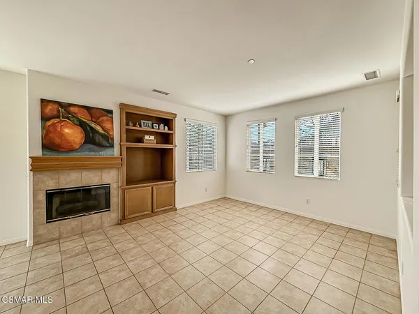 a view of an empty room with window and fire place