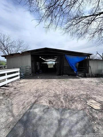 a backyard of a house with a bench and wooden fence