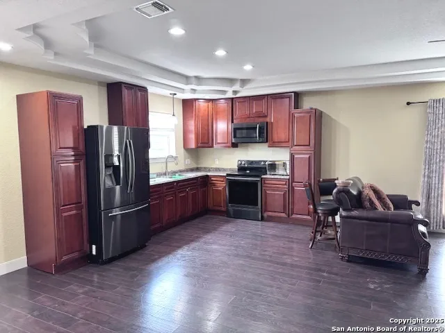 a kitchen with stainless steel appliances granite countertop a refrigerator and a stove
