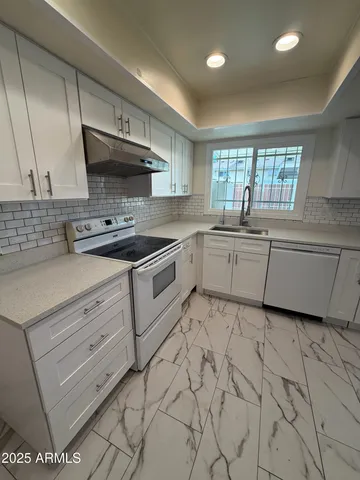 a kitchen with stainless steel appliances granite countertop a sink stove and cabinets