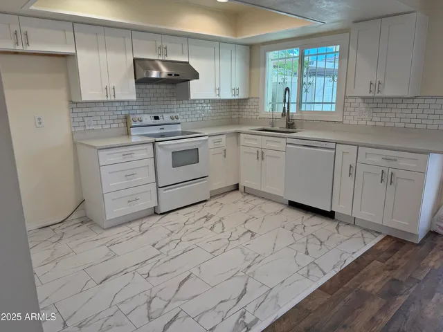 a kitchen with stainless steel appliances granite countertop a sink stove and cabinets