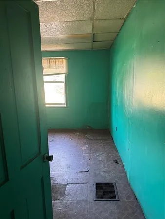 an empty room with chandelier fan