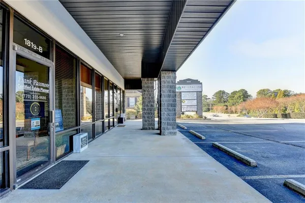 a living room with furniture a flat screen tv and kitchen view