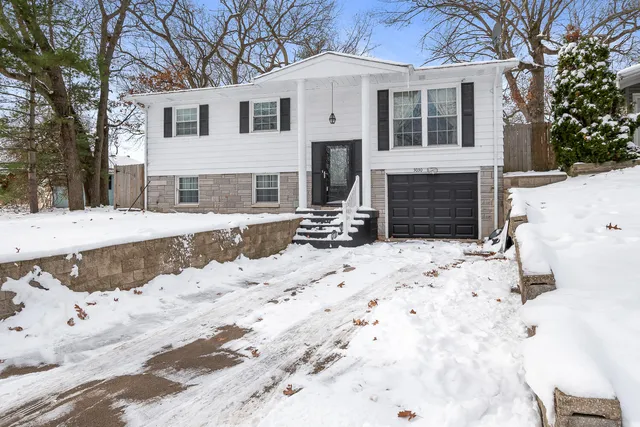 a view of a white house with a yard covered in snow