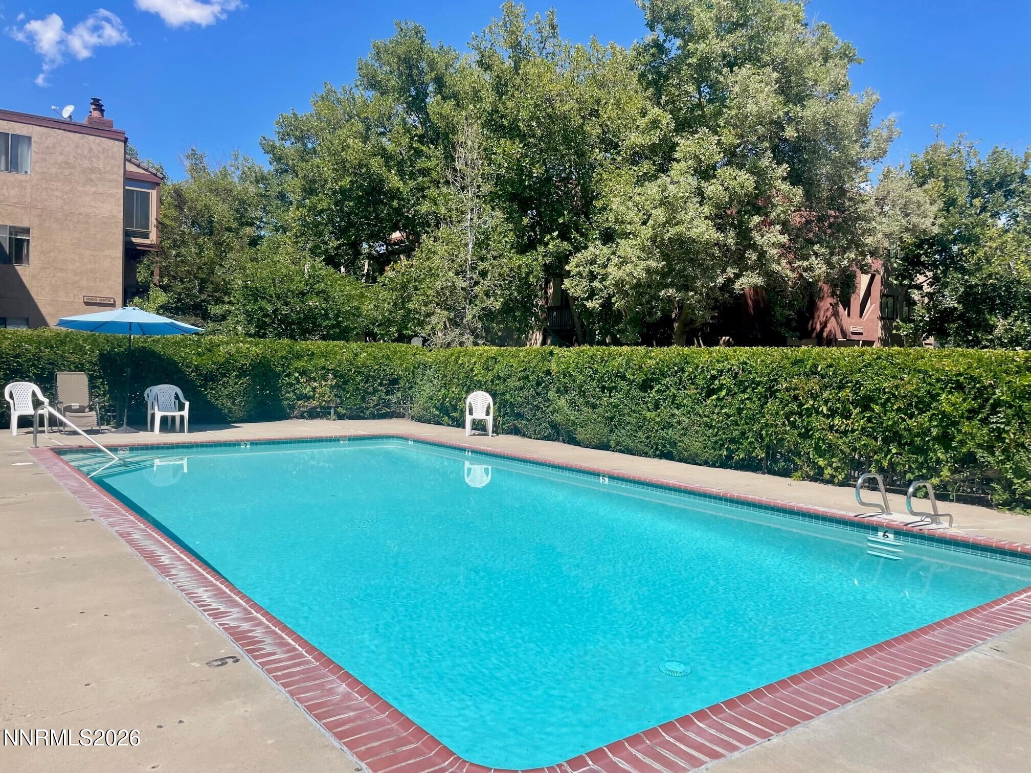 2955 Lakeside Drive, Unit 120 Reno, NV 89509 - Photo 17 of 21 a view of a swimming pool and trees in the background