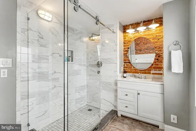 a bathroom with a granite countertop sink a mirror and a shower