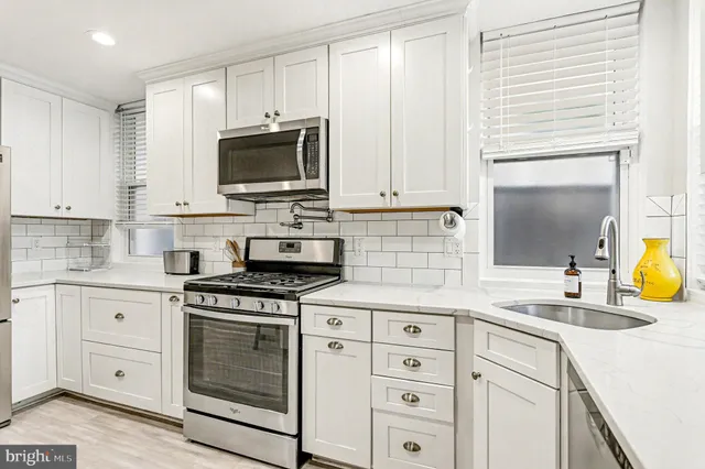 a kitchen with cabinets stainless steel appliances and a sink