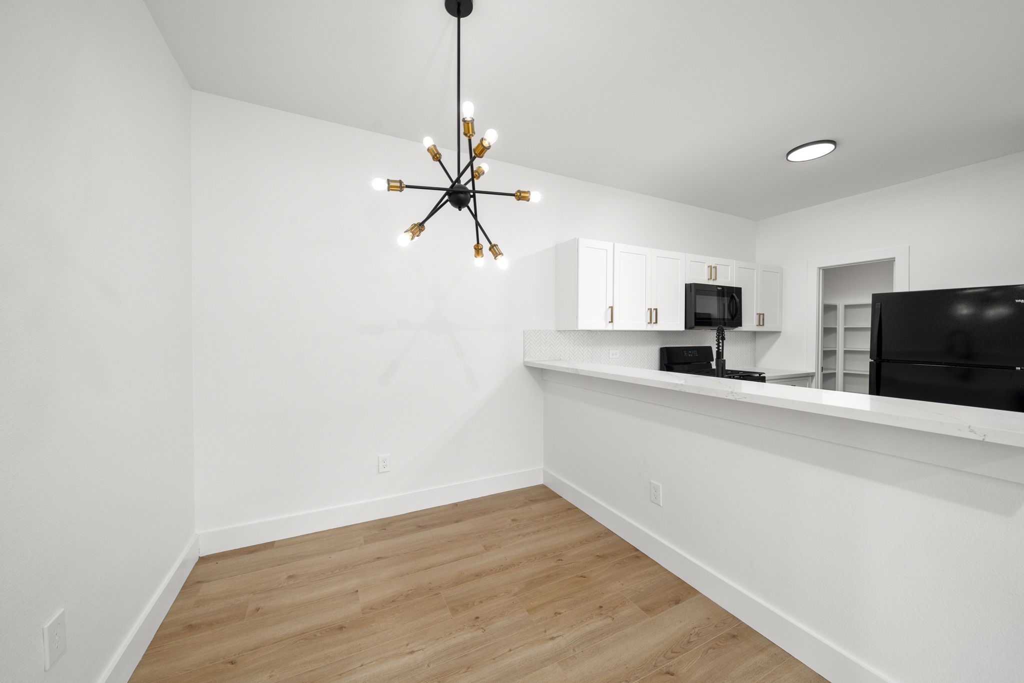 7205 Tippett Street, Unit B Houston, TX 77088 - Photo 13 of 15 a view of a kitchen with a sink a ceiling fan and wooden floor