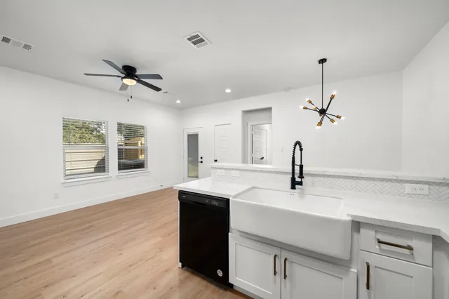 a kitchen with a sink cabinets and wooden floor