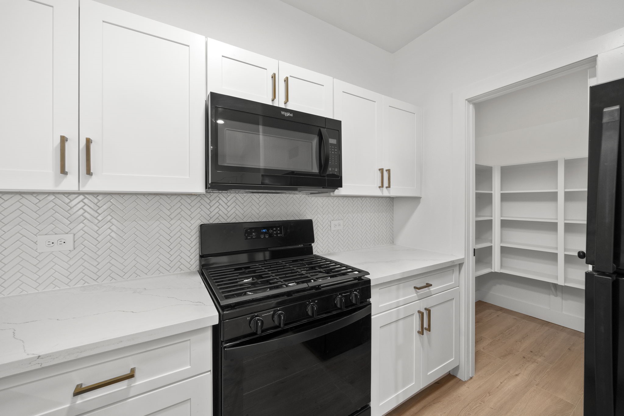 7205 Tippett Street, Unit B Houston, TX 77088 - Photo 5 of 15 a kitchen with stainless steel appliances a stove a microwave and cabinets