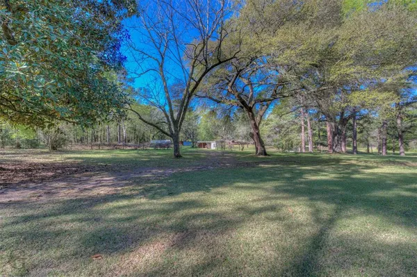 a backyard of a house with lots of green space and fountain