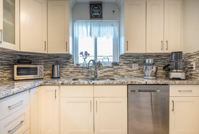 a kitchen with granite countertop a sink and a stove