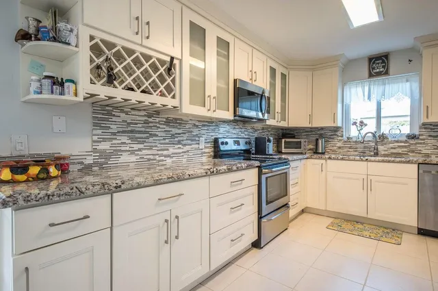 a kitchen with stainless steel appliances granite countertop white cabinets sink and dishwasher