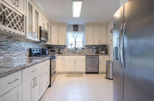 a kitchen with a refrigerator sink and cabinets