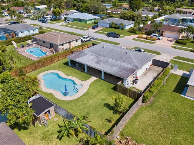 an aerial view of a house with a swimming pool yard and outdoor seating