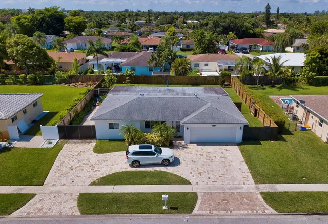 an aerial view of a house with a garden and lake view