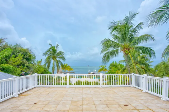 a view of a patio with a dining table and chairs with a small yard