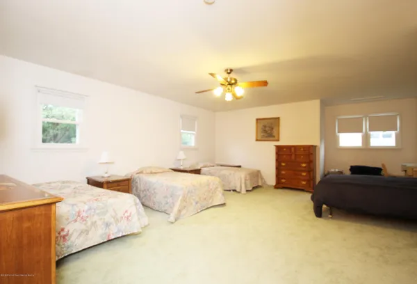 a spacious bedroom with two bed and a chandelier