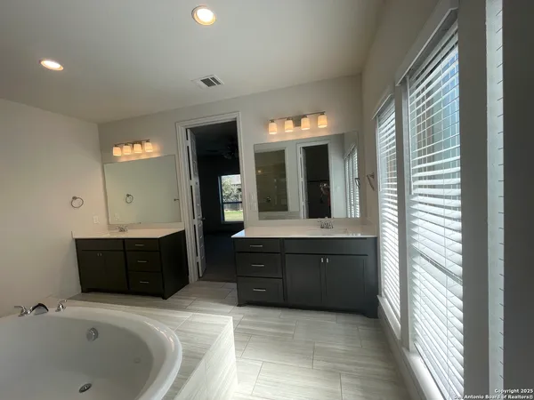a bathroom with a bathtub sink and mirror