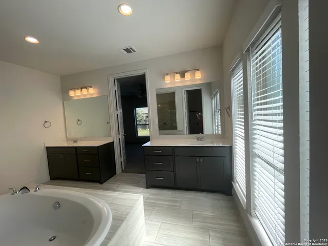 a bathroom with a bathtub sink and mirror