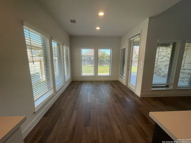 wooden floor in an empty room with a kitchen