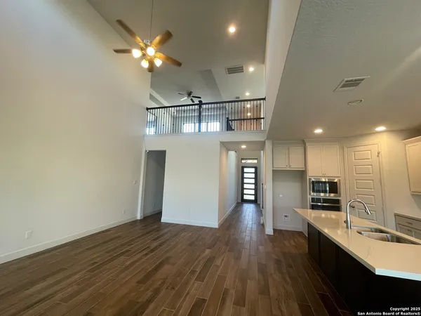 wooden floor in an empty room with a kitchen