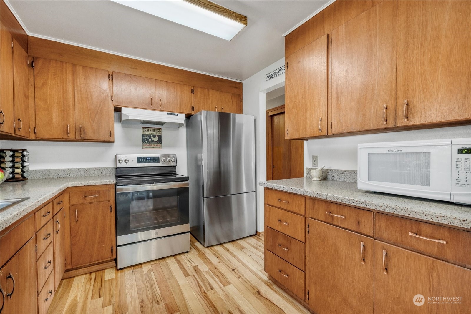 13925 Dubuque Road Snohomish, WA 98290 - Photo 14 of 40 a kitchen with granite countertop wooden cabinets a refrigerator and dishwasher a oven with wooden floors