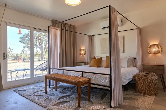 a bedroom with a bed and large windows